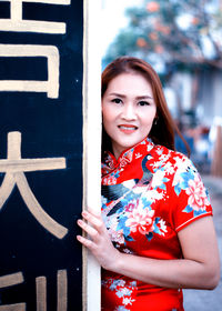 Portrait of smiling young woman standing outdoors