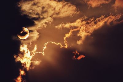 Low angle view of moon in sky at sunset