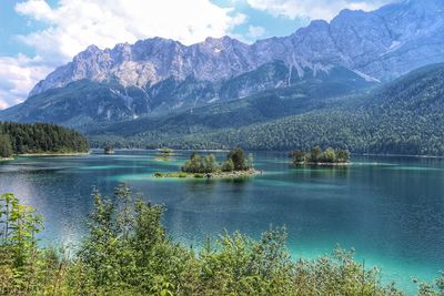 Scenic view of lake by mountains against sky