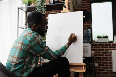 Side view of man using digital tablet at home