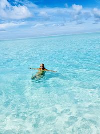 Man surfing in sea against sky