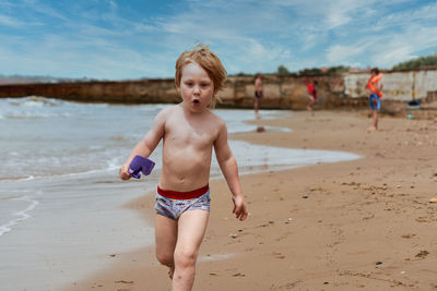 Portrait of shirtless boy playing at beach