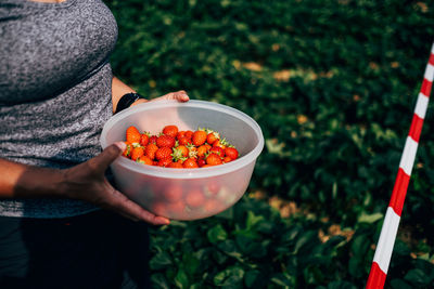 Midsection of man holding fruits