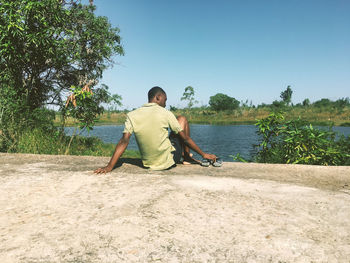 Rear view of man sitting in front of some lake in mozambique