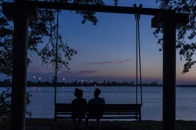 Rear view of silhouette people on beach at night