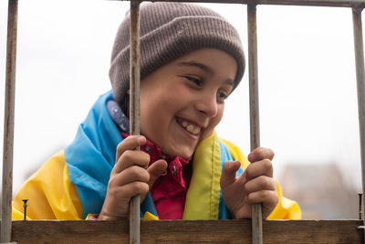 Portrait of boy sitting on railing