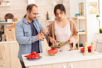 Young couple holding food at home