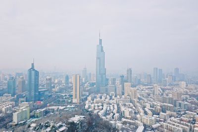 Aerial view of buildings in city against sky