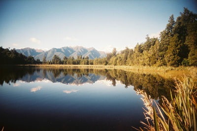 Scenic view of lake and mountains against clear sky