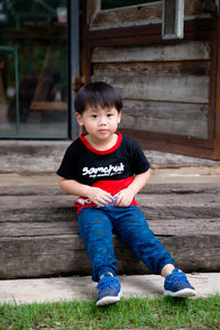 Portrait of cute boy sitting outdoors