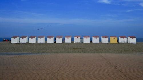 Lifeguard hut on beach against blue sky