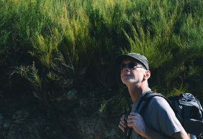 Hiker looking away against plants