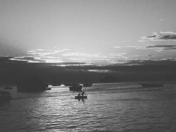 Silhouette person on sea against sky