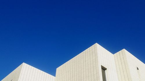 Low angle view of buildings against clear blue sky