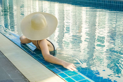 High angle view of woman in hat swimming pool