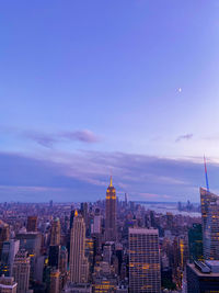 Buildings in city against cloudy sky