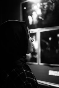 Rear view of woman looking through window