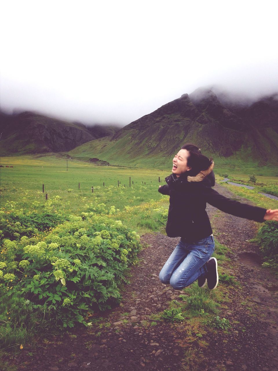 lifestyles, casual clothing, leisure activity, young adult, mountain, landscape, full length, field, grass, standing, sky, young women, nature, tranquil scene, tranquility, person, sitting, beauty in nature