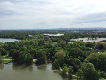 High angle view of trees by sea against cloudy sky