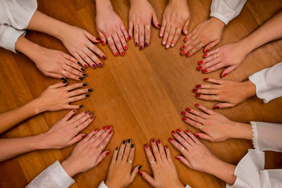 Cropped hands of women with painted fingernails on table