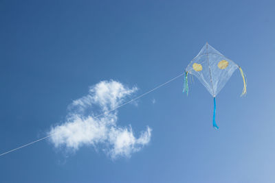 A kite floating in the sky. blue sky and cloud in the background.