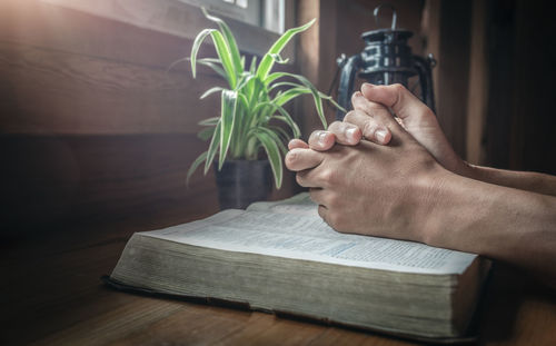 Close-up of hand holding book on table