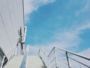 Low angle view of railing against blue sky