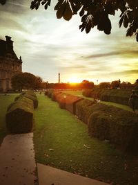 Footpath by historic building against sky during sunset