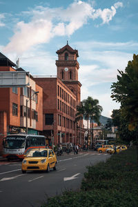 Vehicles on road by buildings in city