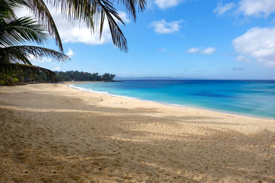 Scenic view of beach against blue sky