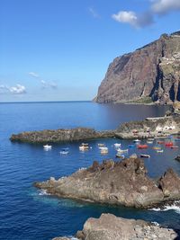 Scenic view of sea with boats against sky