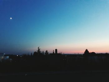 Silhouette city against clear sky during sunset