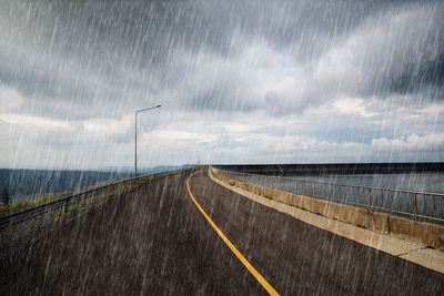 Road against cloudy sky during rainy season