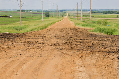 Dirt road passing through field