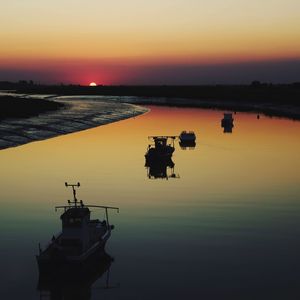 Silhouette boat in sea against sky during sunset