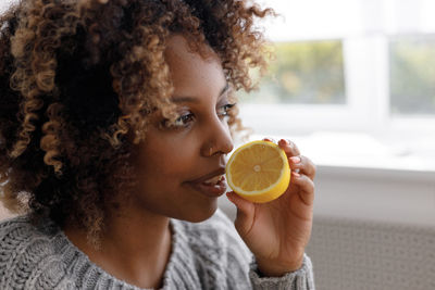 Portrait of young woman holding fruit