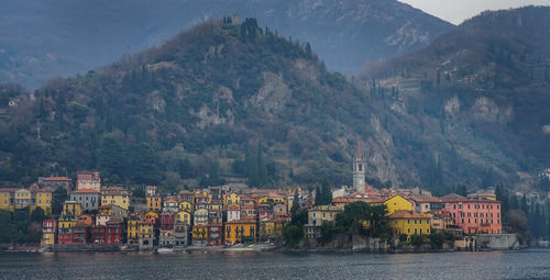 Scenic view of river by buildings and mountains
