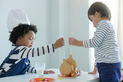 Side view of boys preparing food on table