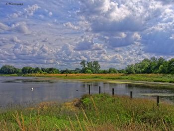 Scenic view of lake against cloudy sky