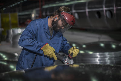 Factory worker operating steel cutter