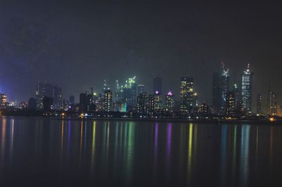 Illuminated city skyline against sky at night