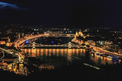 Aerial view of illuminated bridges over river against sky at night