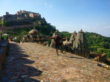 Full length of man standing on one leg against historical buildings