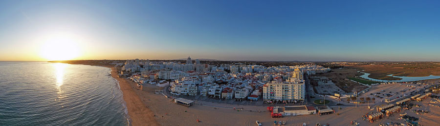 High angle view of crowd at beach against sky during sunset