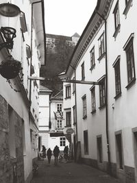 People walking on street amidst buildings in city