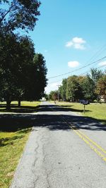 Empty road with trees in background