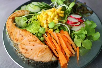 High angle view of salad served in plate with salmon grill.