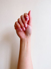 Close-up of human hand against white wall