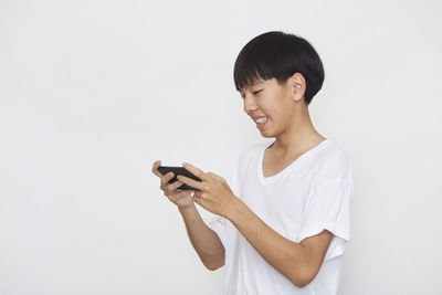 Young man using mobile phone against white background