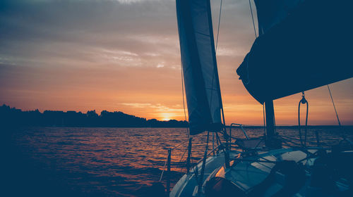 Sailboat in sea against sky during sunset